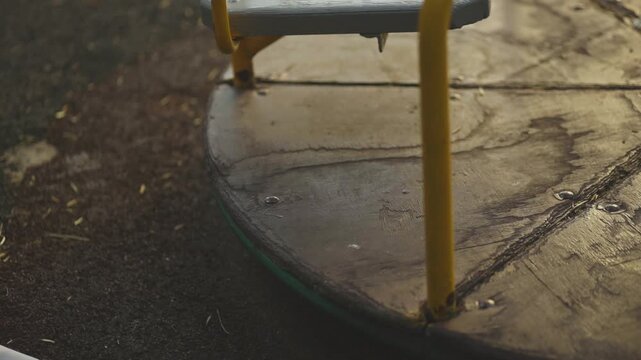 A child puts his foot on a destroyed carousel. Post-apocalypse
