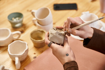 Stylish man creates unique pottery in a vibrant ceramics studio filled with creativity
