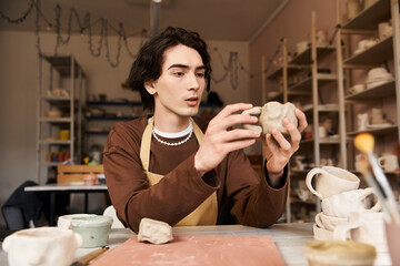 Handsome stylish man exploring creativity in a pottery studio while crafting unique ceramics