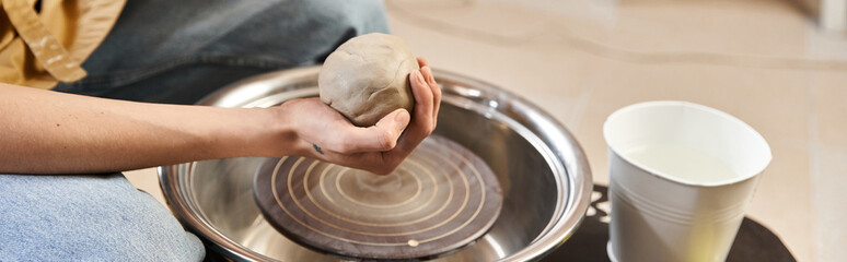 Creative hands shaping clay in an artistic pottery studio filled with inspiration