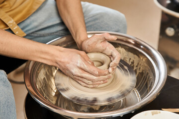 Handsome stylish man creates unique pottery in a bright ceramics studio filled with creativity