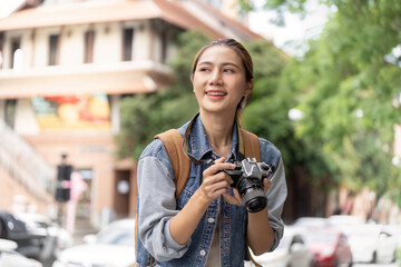 Happy young woman photographer exploring city with camera
