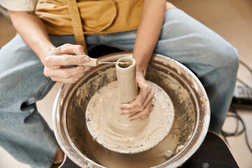 Stylish man passionately shaping clay in a pottery studio filled with artistic inspiration