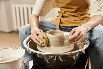 Handsome stylish man crafting pottery in an inspiring ceramics studio environment