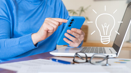 Businesswoman working from home, using a smartphone and laptop while a light bulb icon symbolizes a brilliant idea for her business, reflecting innovation and creativity