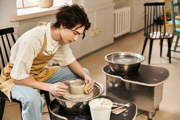 Handsome stylish man creating pottery in a vibrant studio filled with creativity and artistry