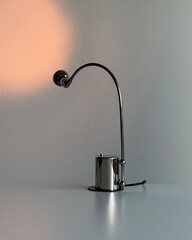 Curved chrome desk lamp casts soft spotlight.
