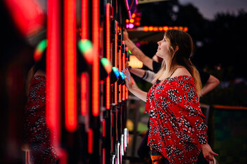 Focused Woman Playing Light Game at Night Carnival