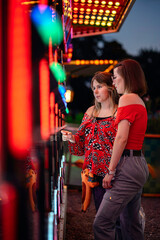 Friends Chatting Beside Carnival Light Game Booth