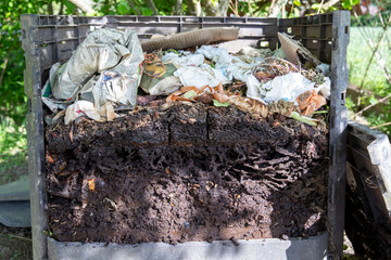 Ouverture d'un bac à compost de jardin extérieur rempli de déchets alimentaires et de déchets...
