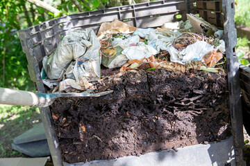 Ouverture d'un bac à compost de jardin extérieur rempli de déchets alimentaires et de déchets organiques en décomposition. Couches déchets organiques de compost, engrais naturel.
