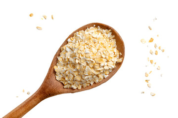 Rolled oats in a wooden spoon some oats falling down on black background
