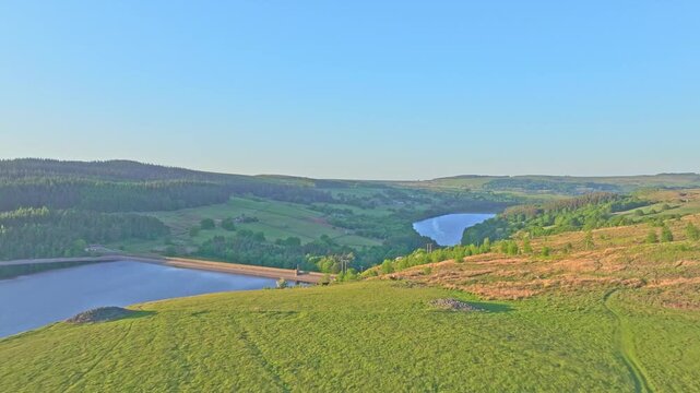 Push in drone shot of Strines Reservoir, water storage reservoir, with forest during the day near Sheffield, South Yorkshire, England
