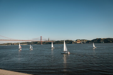 Bright and clear view of Lisbon’s famous 25 de Abril Bridge crossing the Tagus River, with...