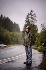 Person Standing Quietly on Rainy Road in Forest Setting