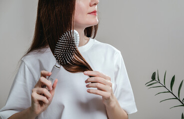 Woman styling hair using comb. Health care, beauty treatment, hair loss problem.Treatment for hair loss due to stress and depression