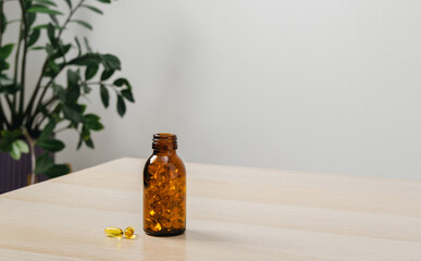 Omega-3 fish oil capsules in transparent bottle stands on the table