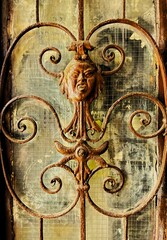 Door decorated with blacksmithing, rusty texture.