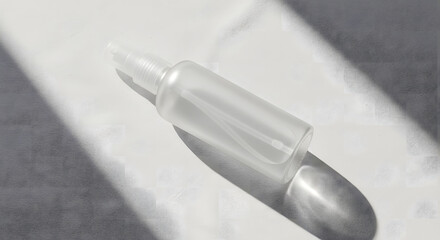 A clear, empty spray bottle lies on a white surface, casting a sharp shadow in bright sunlight.