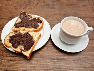 Delicious breakfast idea, toast with chocolate spread and cup of latte coffee