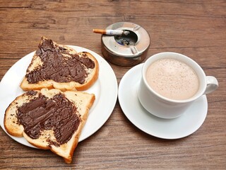 Delicious breakfast idea, toast with chocolate spread and cup of latte coffee