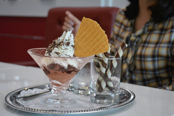 People are eating ice cream and snacks in a shop.