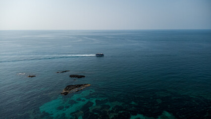 Red-Roof Boat, Coral Reef, and Turquoise Waters – Aerial View of Mediterranean Coast in Calabria,...