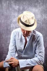 Man posing with a fedora covering his face. The man is forty years old, of Caucasian origin and...