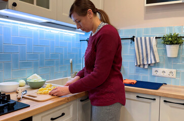 A woman crafts homemade borscht in a rustic kitchen, capturing the heart of heritage cooking with...