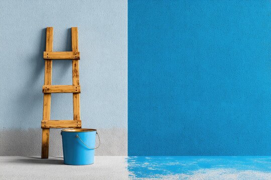 Paint job in progress.  Wooden ladder and blue bucket beside a wall half painted blue