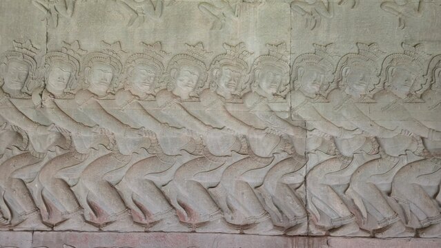 Angkor Wat, Cambodia - 3 July 2025. Stone relief shows asuras pulling the serpent Vasuki in rhythmic unison during the Churning of the Ocean of Milk myth.