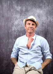 Man portrayed wearing a white and light blue summer shirt and a white fedora. The man is forty years old and of Caucasian origin