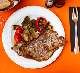 Appetizing beef steak with stewed bell peppers and vegetables