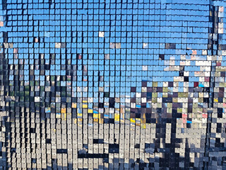 Reflective mosaic pattern with blue sky and urban landscape creating a vibrant visual experience