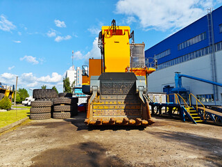 Large yellow excavator with a powerful digging arm, positioned on a construction site, surrounded...
