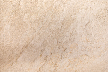 Close-up view of textured beige stone surface with subtle patterns and natural variations in color