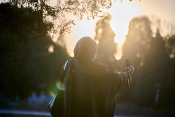 Woman in brown abaya at sunset in the park