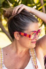 Woman with Partially Gray Long Hair and Modern Glasses. Embracing the Transition to Natural Hair