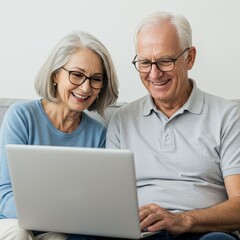 Smiling seniors enjoy laptop together on a sofa.