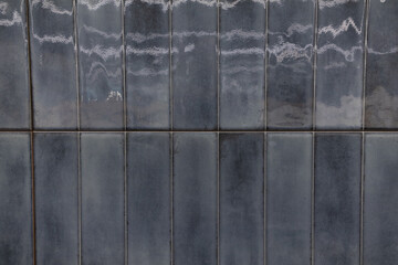 Elegant ceramic tile wall showcasing varying shades of gray with a glossy finish in a contemporary...