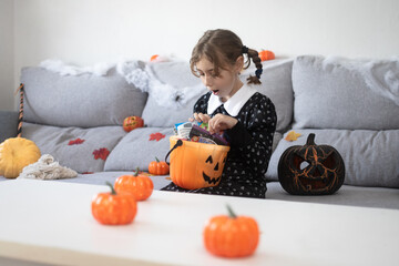 Girl opening Halloween candy bucket with surprised face
