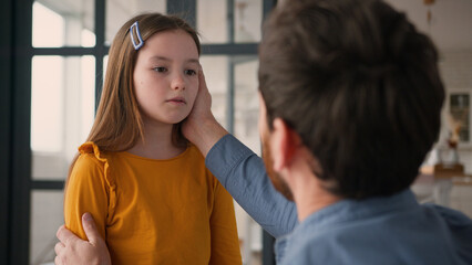 Caring Caucasian dad man guy male touching talk offended sad little child kid at home babysitter...