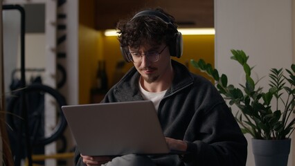 Concentrated Caucasian guy working laptop at home man freelancer programmer chatting website...
