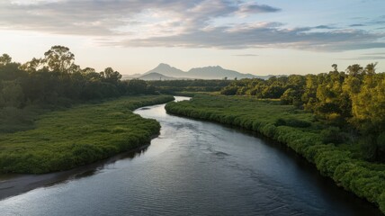 Serene river landscape with verdant banks and distant mountain range at sunset