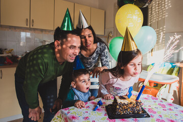 Family celebrating birthday with cake and balloons