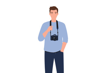 A man with a camera around his neck one hand in his pants pocket