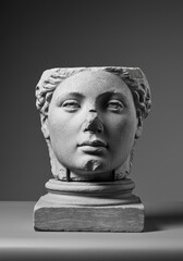 Ancient marble head sculpture on a pedestal