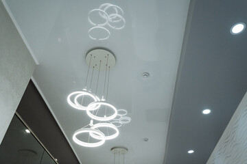 A modern chandelier featuring a unique ring design that elegantly casts beautiful light reflections...