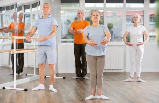 Group of elderly people of different ages are learning various dance and ballet movements in the studio - Powered by Adobe