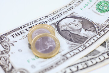 Euro coins and dollar bills on white background